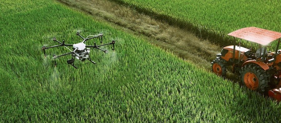 Drone e trattore al lavoro sullo stesso campo di grano