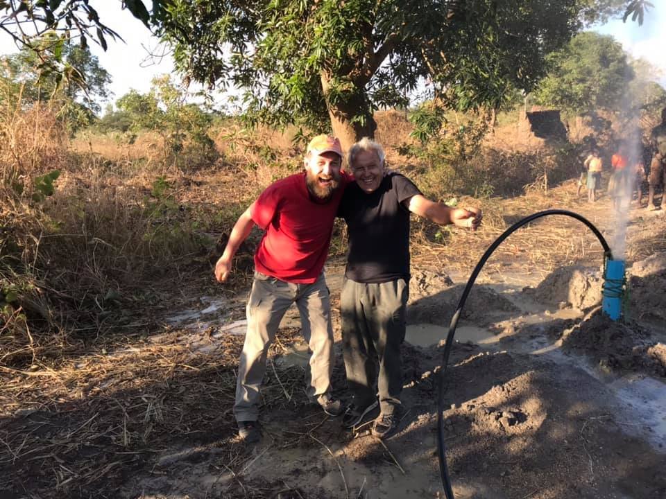 Due volontari accanto al pozzo appena trivellato in Malawi