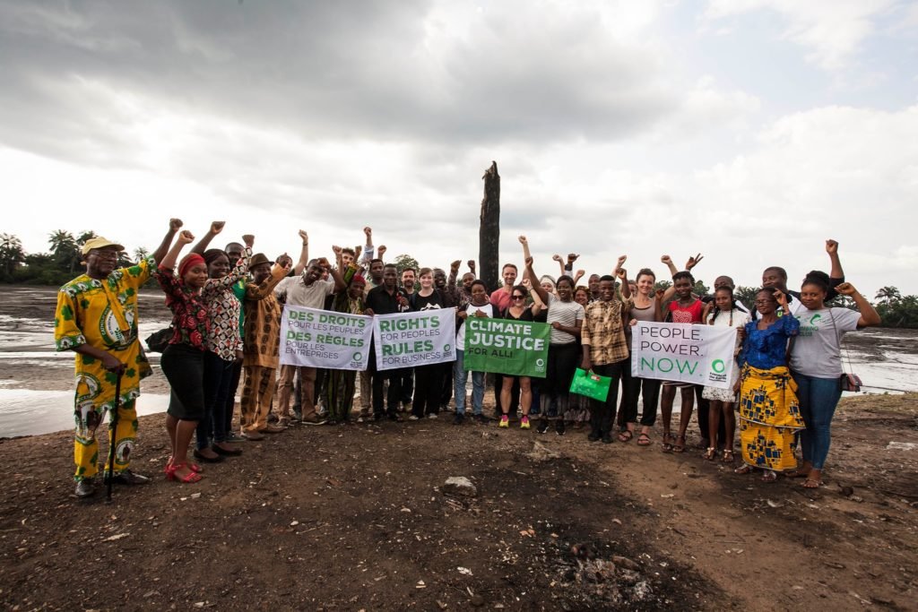Manifestanti nigeriani con cartelli contro Shell