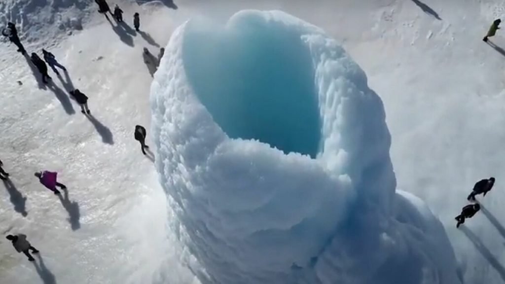 Persone accanto a una grotta di ghiaccio