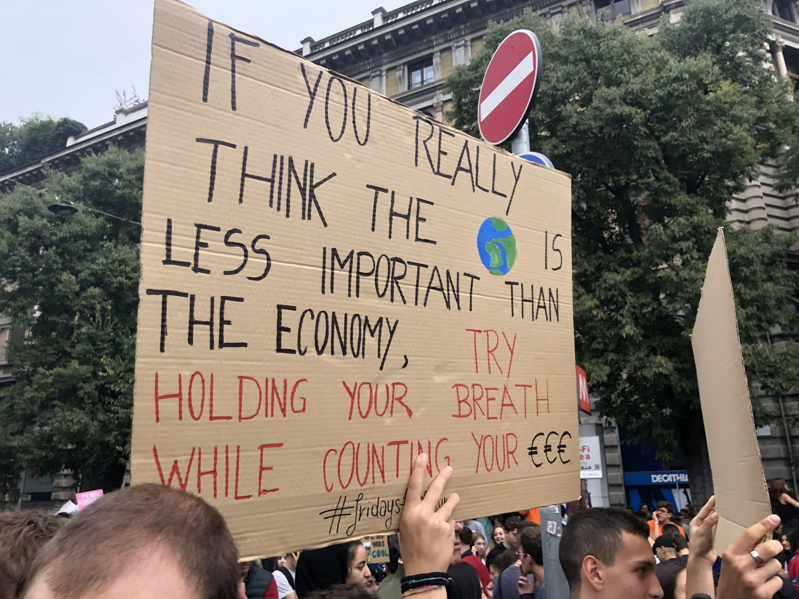 Cartello sull'economia contro l'ambiente al corteo di Milano